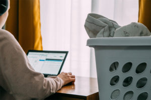 member working from home with laundry basket sitting on desk